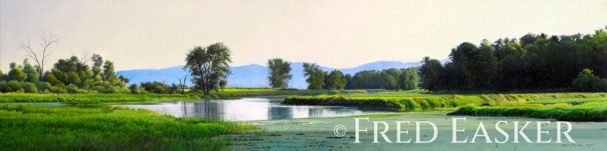 A peaceful river winds through green fields and trees under a pale sky with distant hills.